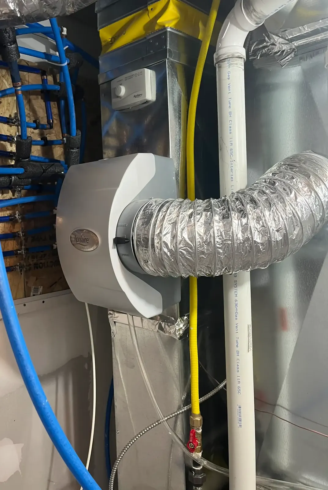 ZK Mechanical technician installing a high-efficiency furnace and humidifier in a Toronto home