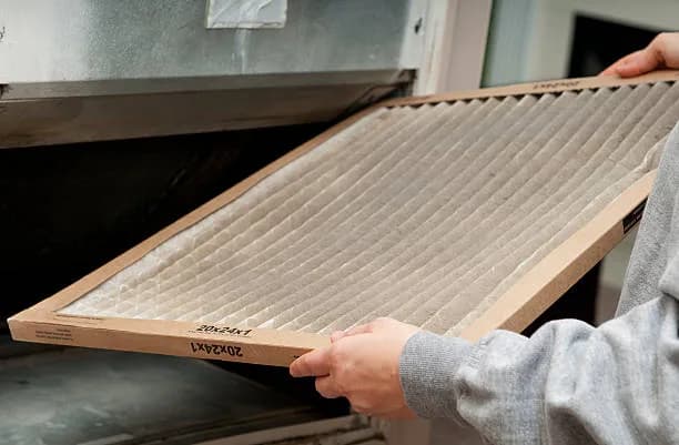 Homeowner replacing a furnace filter in a GTA home
